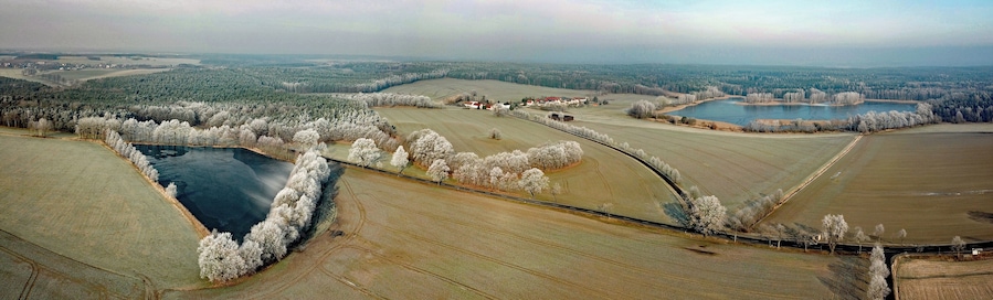 An aerial view of a rural landscape with fields, a river, and a small town.