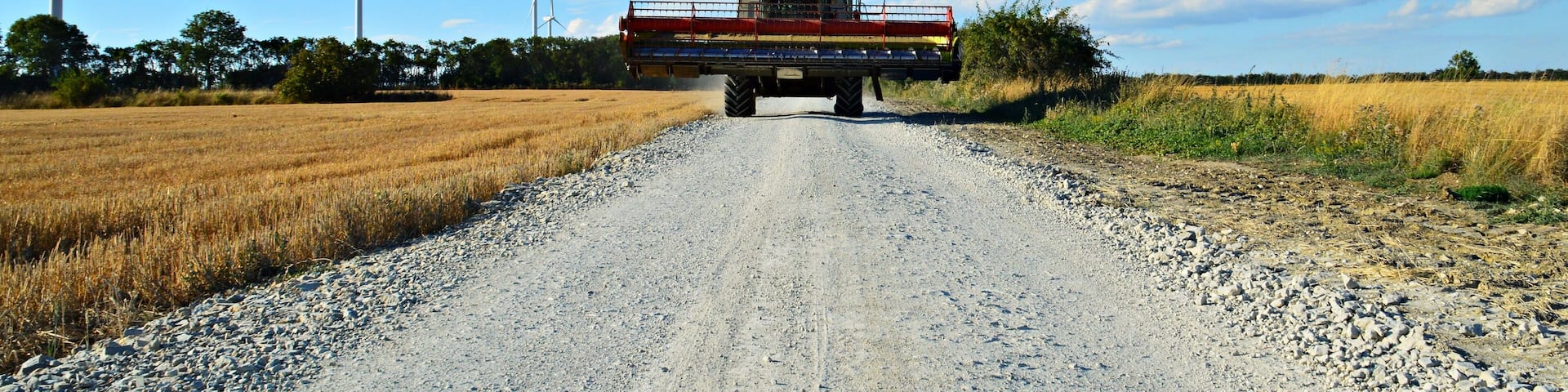 Begegnung beim Radfahren, ein Mähdrescher in voller Breite unterwegs auf der Hainleite bei Holzengel im thüringischen Kyffhäuserkreis.