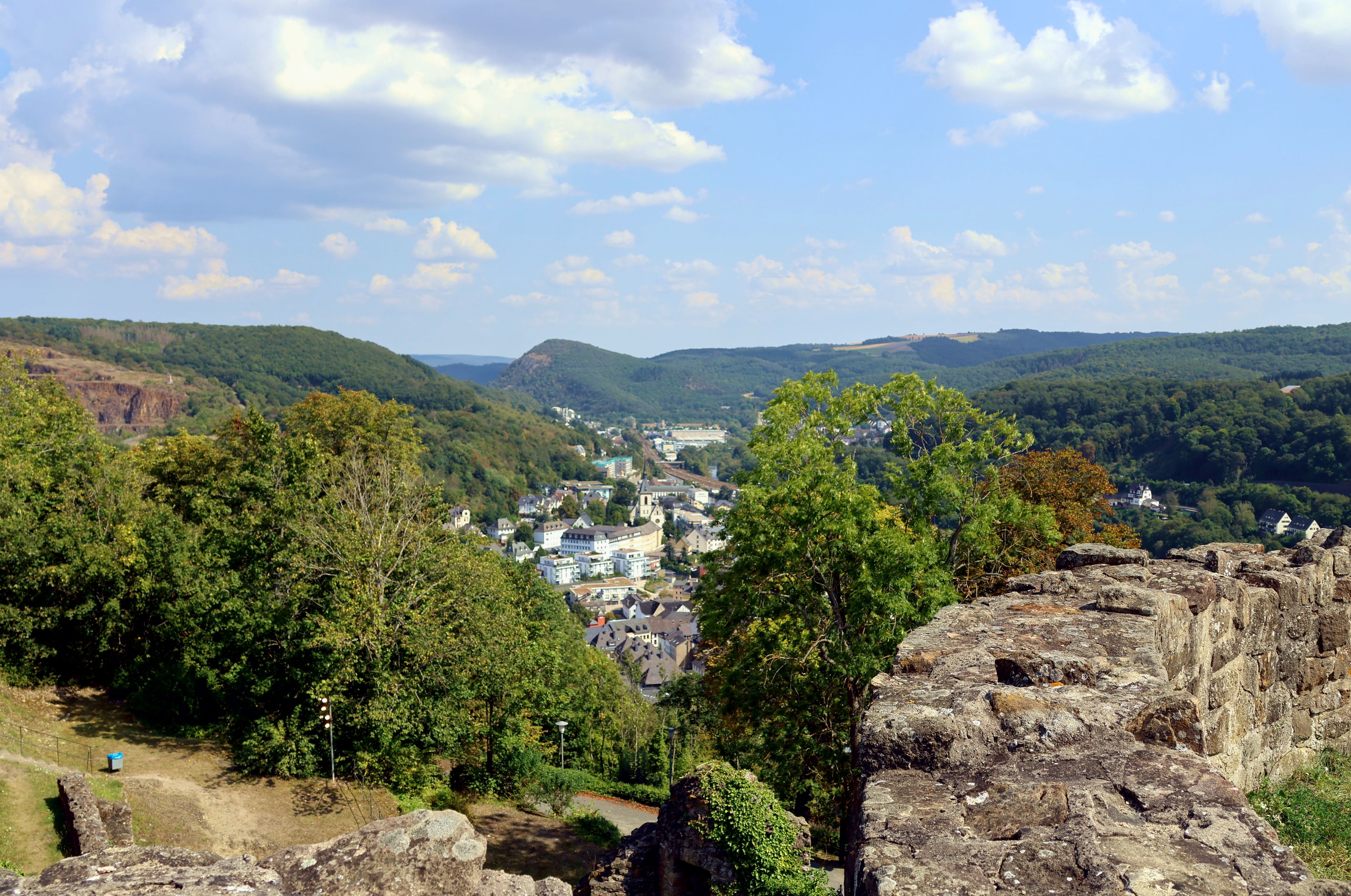 A town nestled in a valley with a prominent church and surrounding hills.