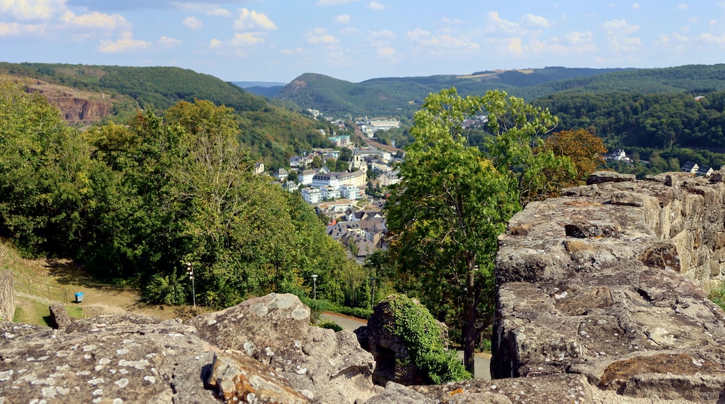 A town nestled in a valley with surrounding hills and a clear sky.