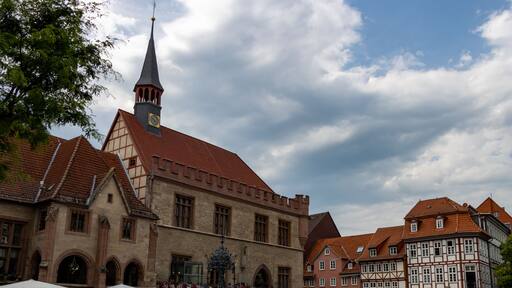 Ein historisches Gebäude mit einem Glockenturm, umgeben von traditionellen Fachwerkhäusern.