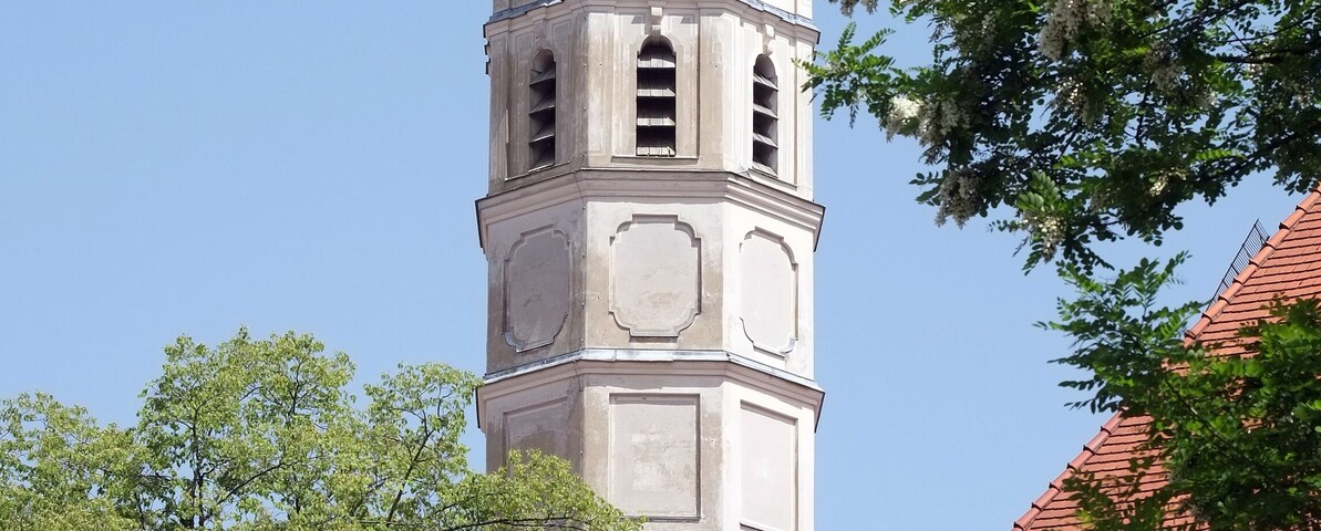Una torre de iglesia con una cúpula verde y un reloj.