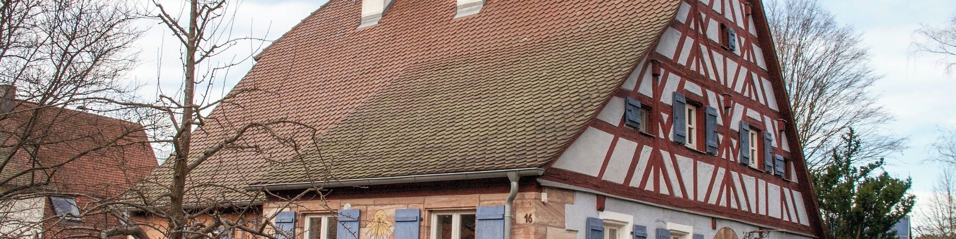 A traditional half-timbered house with a sloped roof and chimneys.