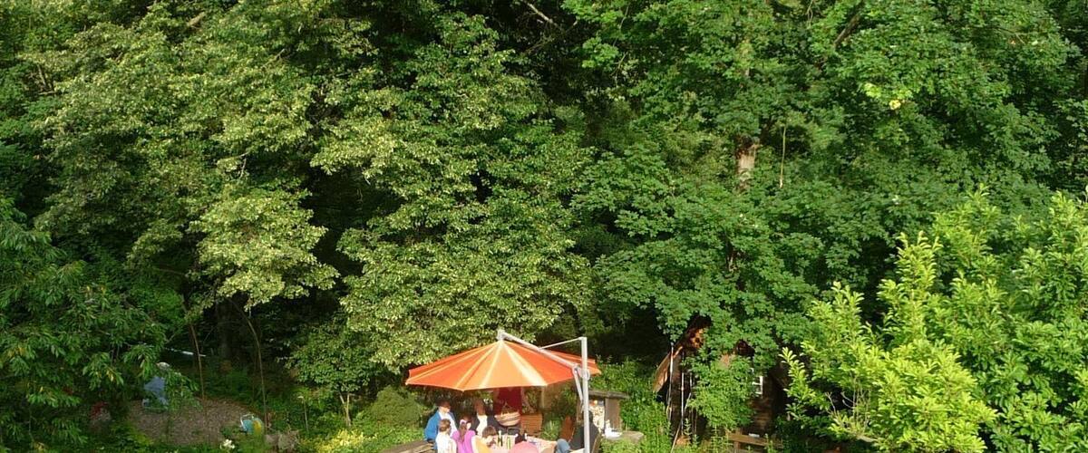 A garden with a gazebo, people sitting, and lush greenery.