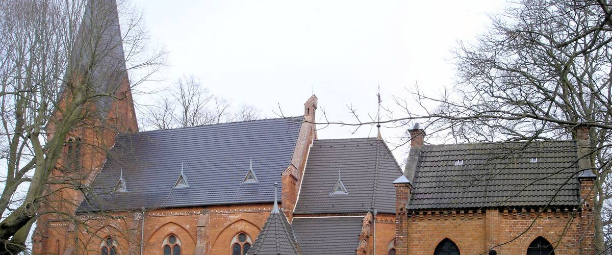 A historic church with a tall steeple and arched windows.