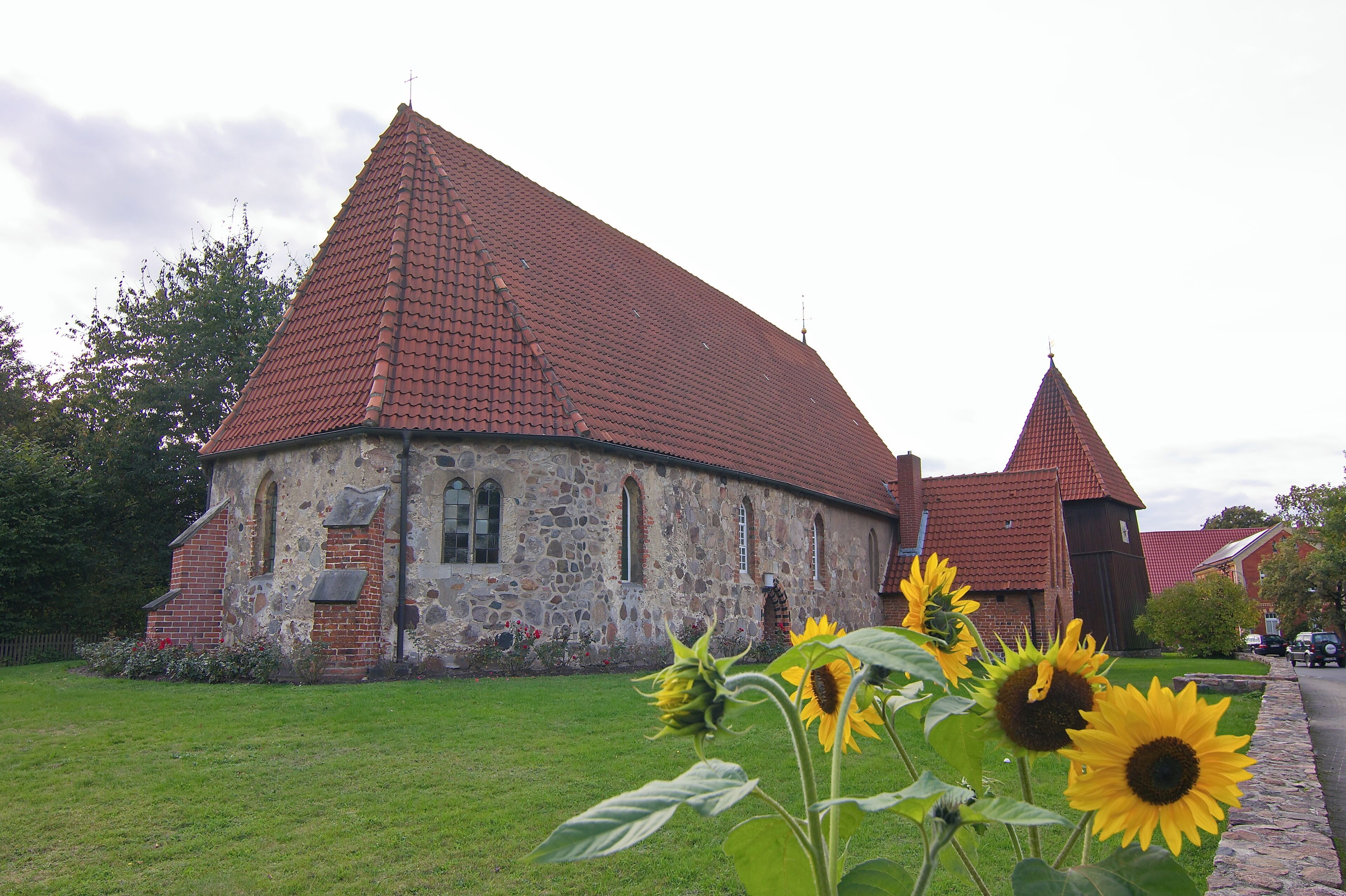 A stone church with a red-tiled roof and a bell tower.
