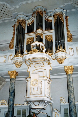 Un órgano ornamentado con detalles dorados y columnas de mármol.
