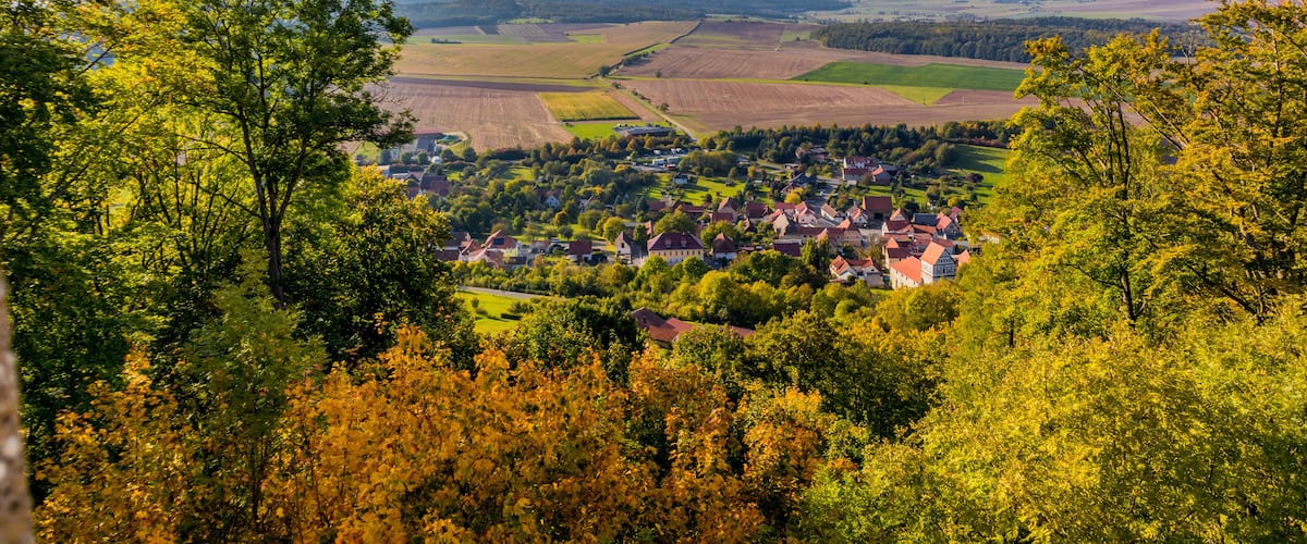 Un paysage rural avec un village niché au milieu de champs et de collines.