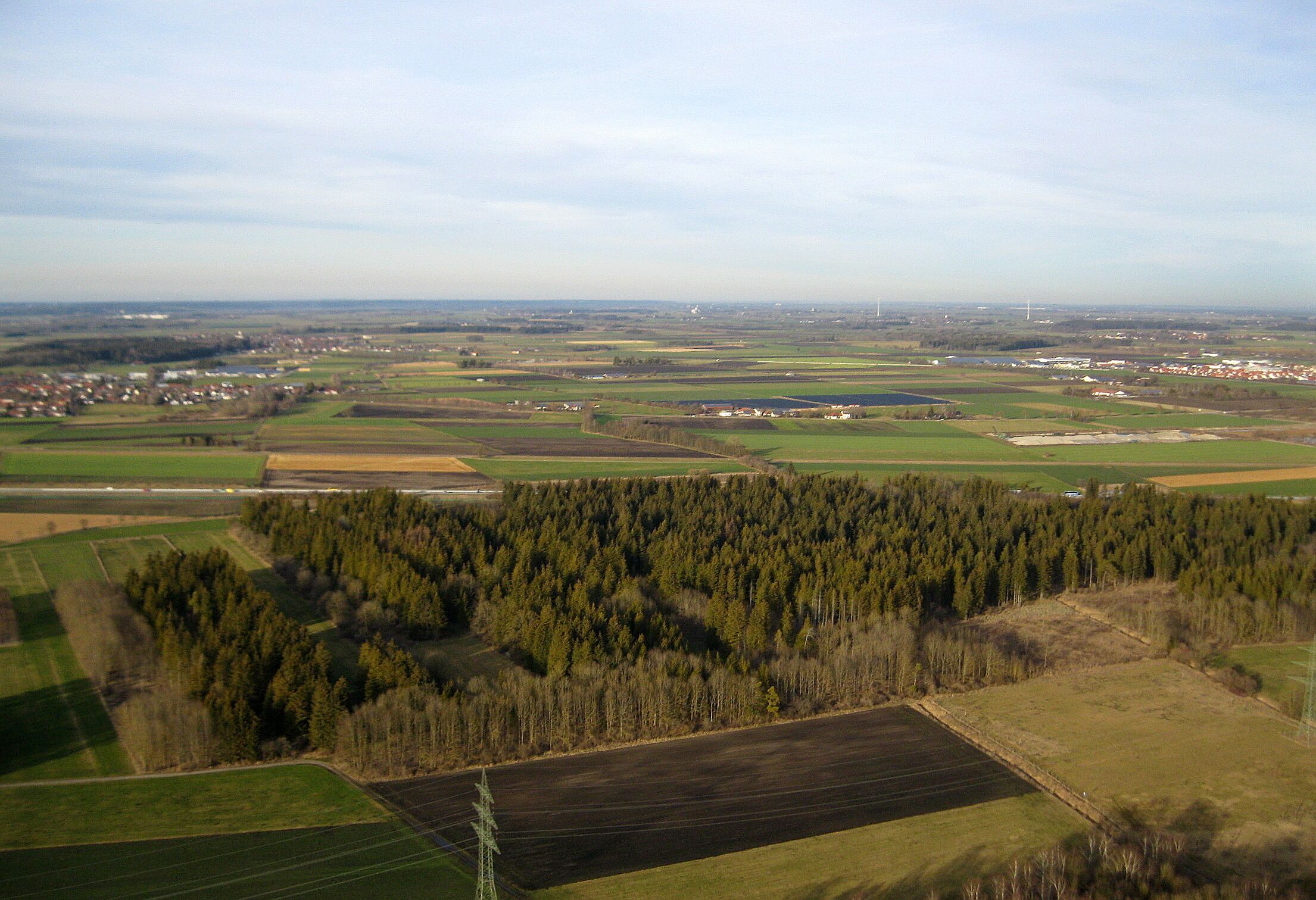 Das Wiedergeltinger Wäldchen von Süden. Unmittelbar im Hintergrund die quer durch das Bild verlaufende Autobahn 96 München-Lindau.