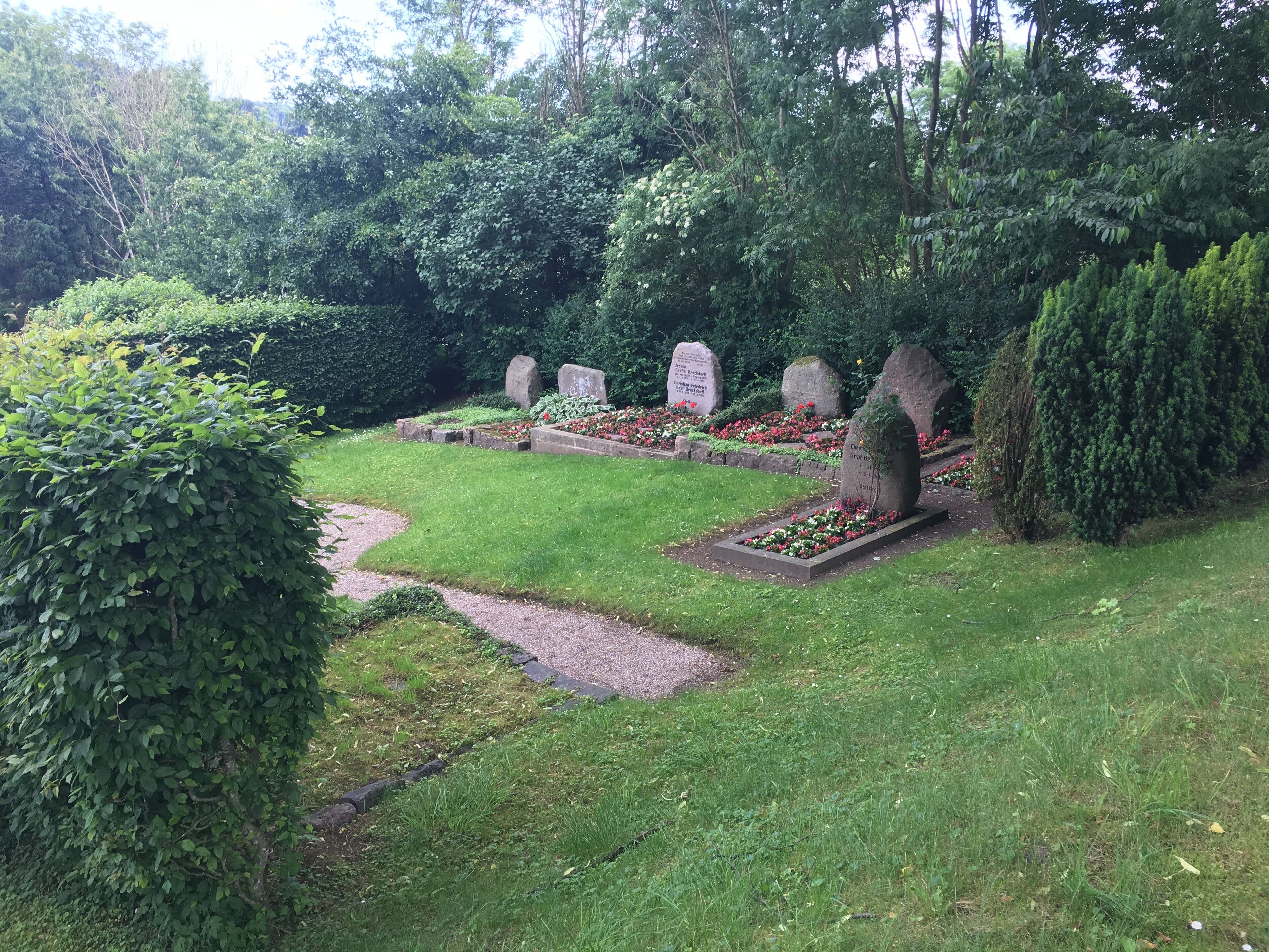 A cemetery with headstones and flower beds.