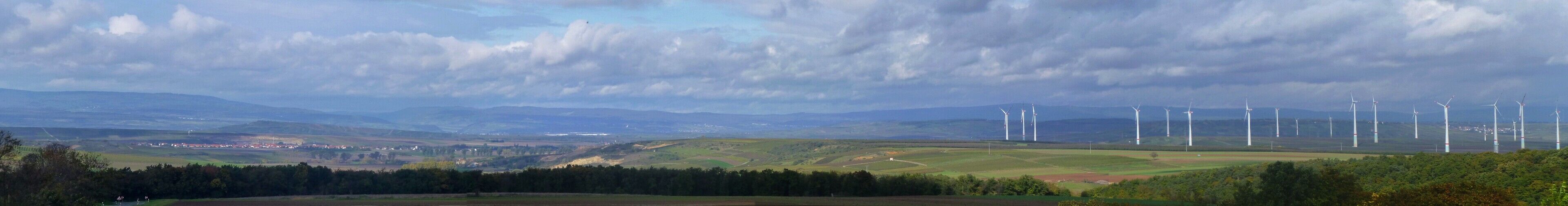 A landscape with wind turbines and rolling hills.