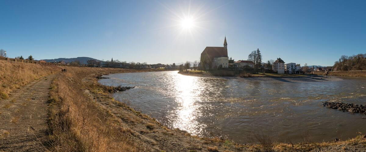 A river with a church and buildings in the background.