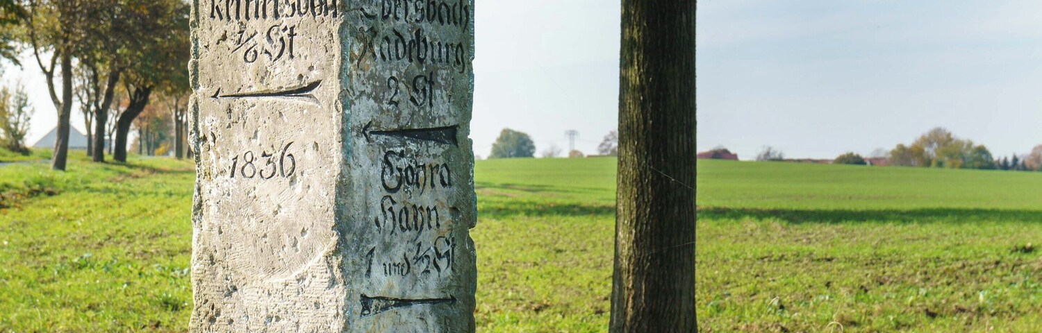 Un monumento de piedra con inscripciones en un entorno rural.