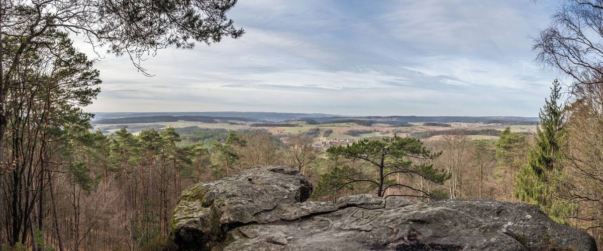A mountainous landscape with rocky outcrops and dense forests.