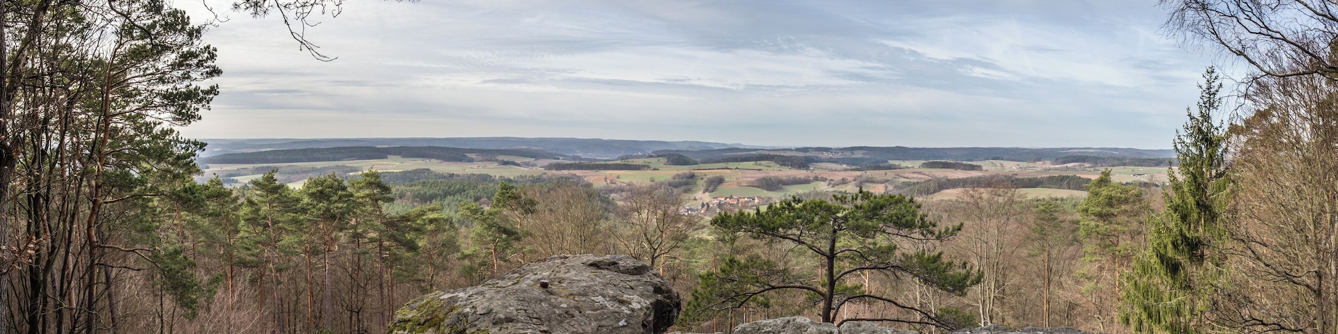 A mountainous landscape with rocky outcrops and dense forests.