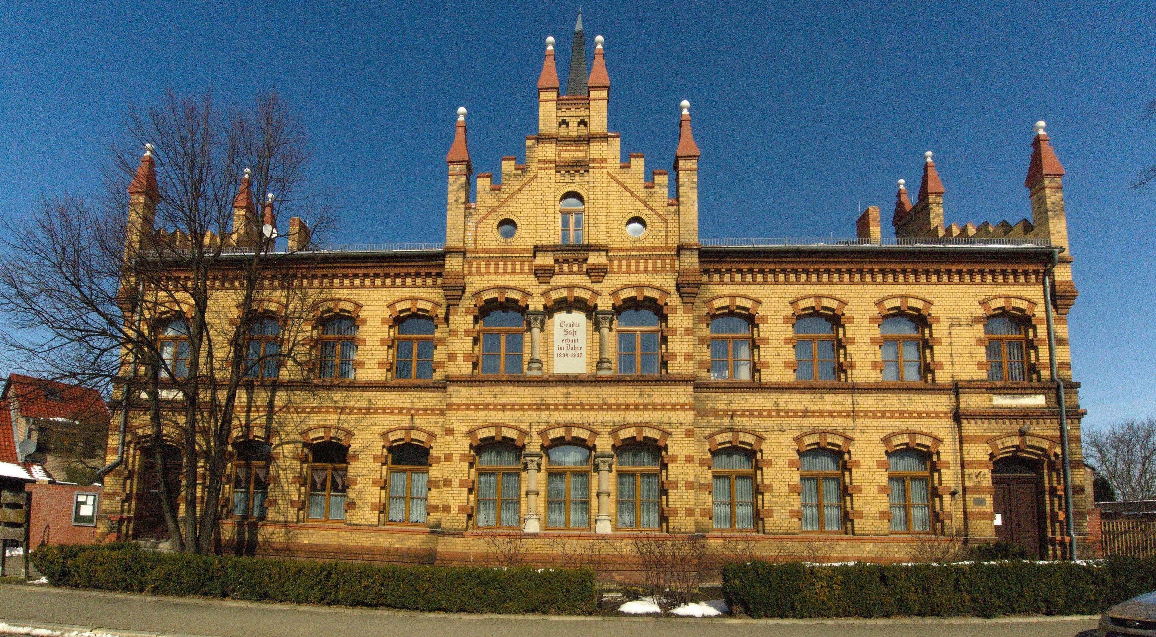 A large, ornate building with multiple towers and arched windows.