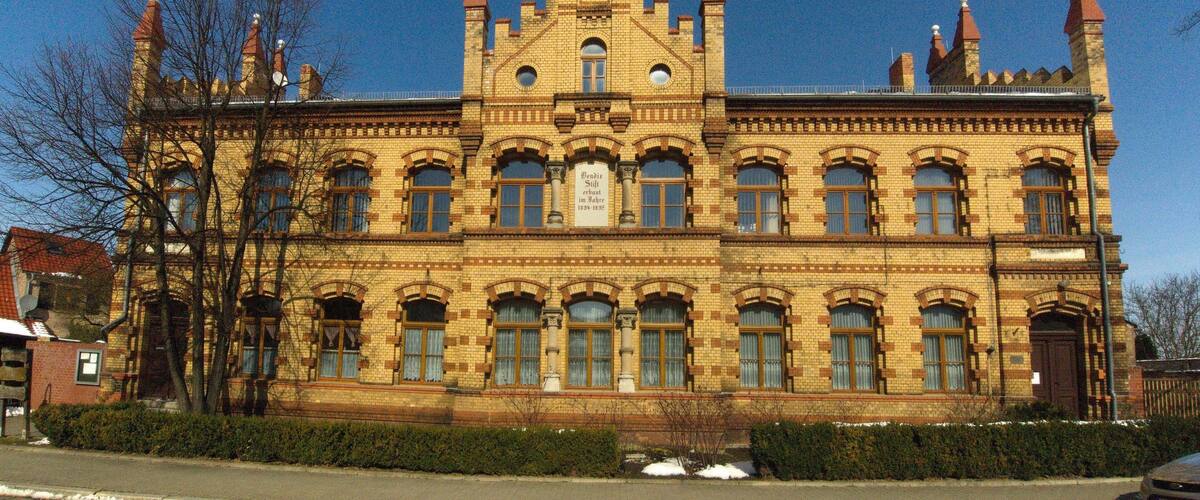 A large, ornate building with multiple towers and arched windows.
