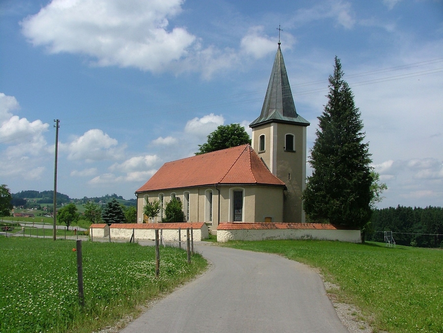 A church with a red roof and a tall steeple.