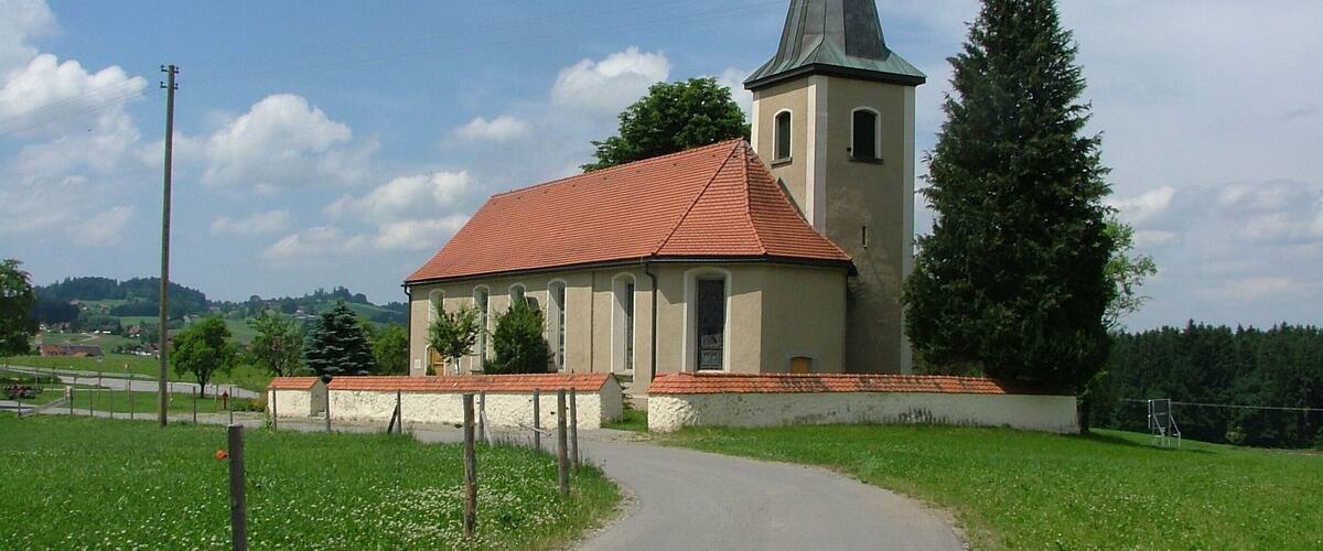 A church with a red roof and a tall steeple.