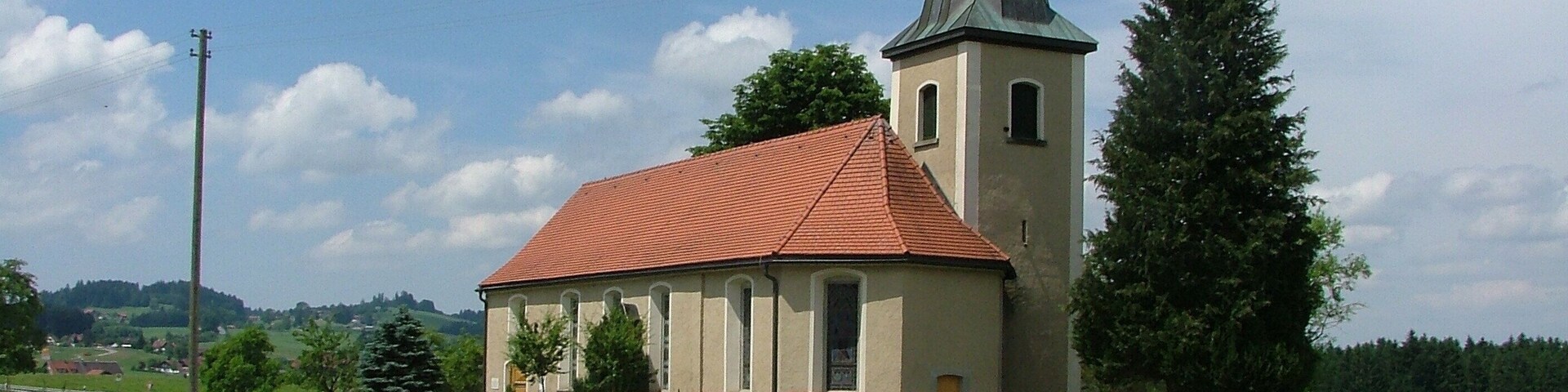 A church with a red roof and a tall steeple.