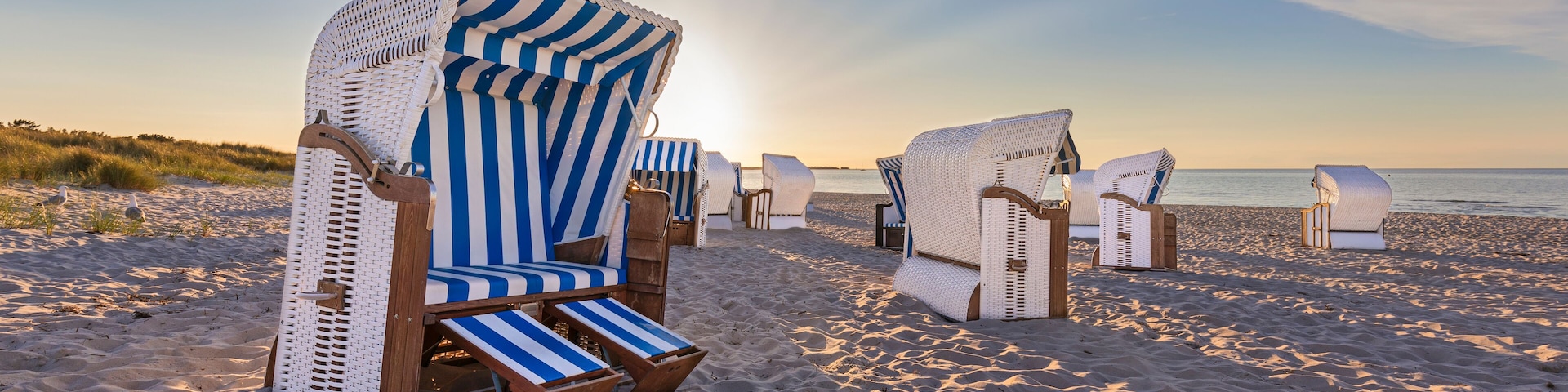 Sunset at calm beach with beach chairs