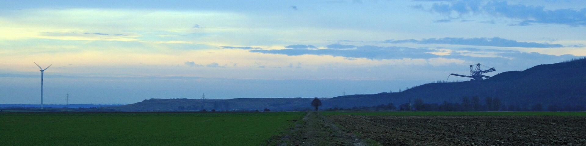 Landschaft im Rheinischen Braunkohlerevier mit Windkraftanlage und Hochkippe (Sophienhöhe?) mit aktivem Absetzer; von Titz aus aufgenommen