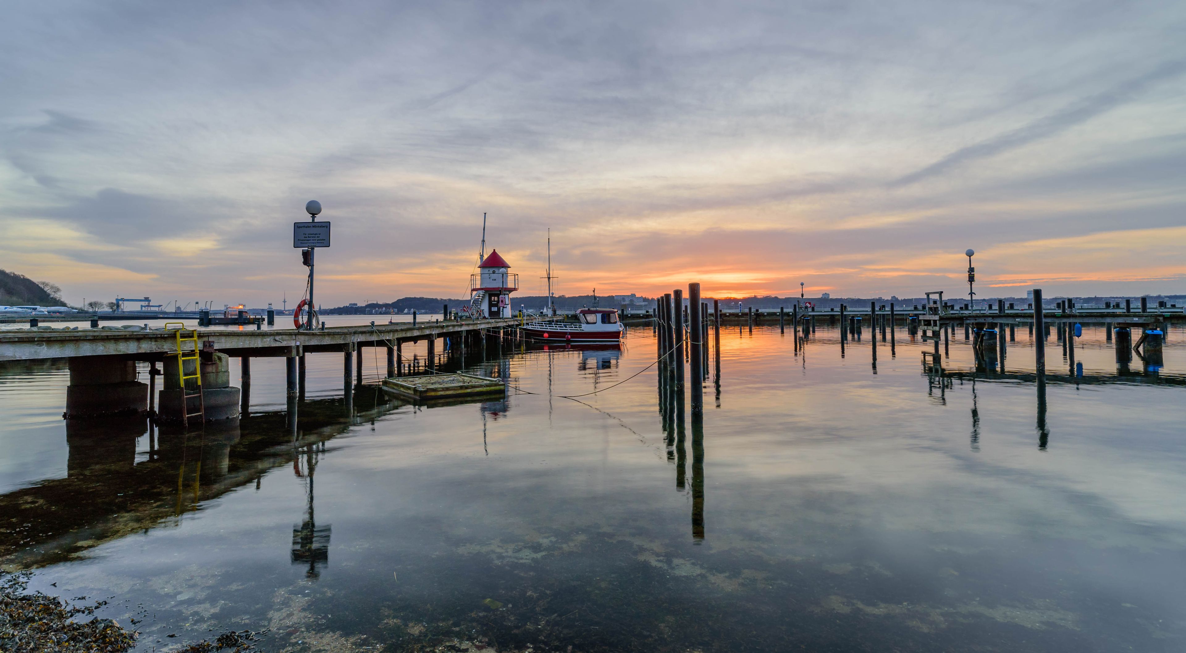 View of marina of Mönkeberg with the red and white tiny lighthouse,"Juliusturm". Signboard "Mönkeberg sports harbor
Entry to the private facilities is not permitted for unauthorized person."