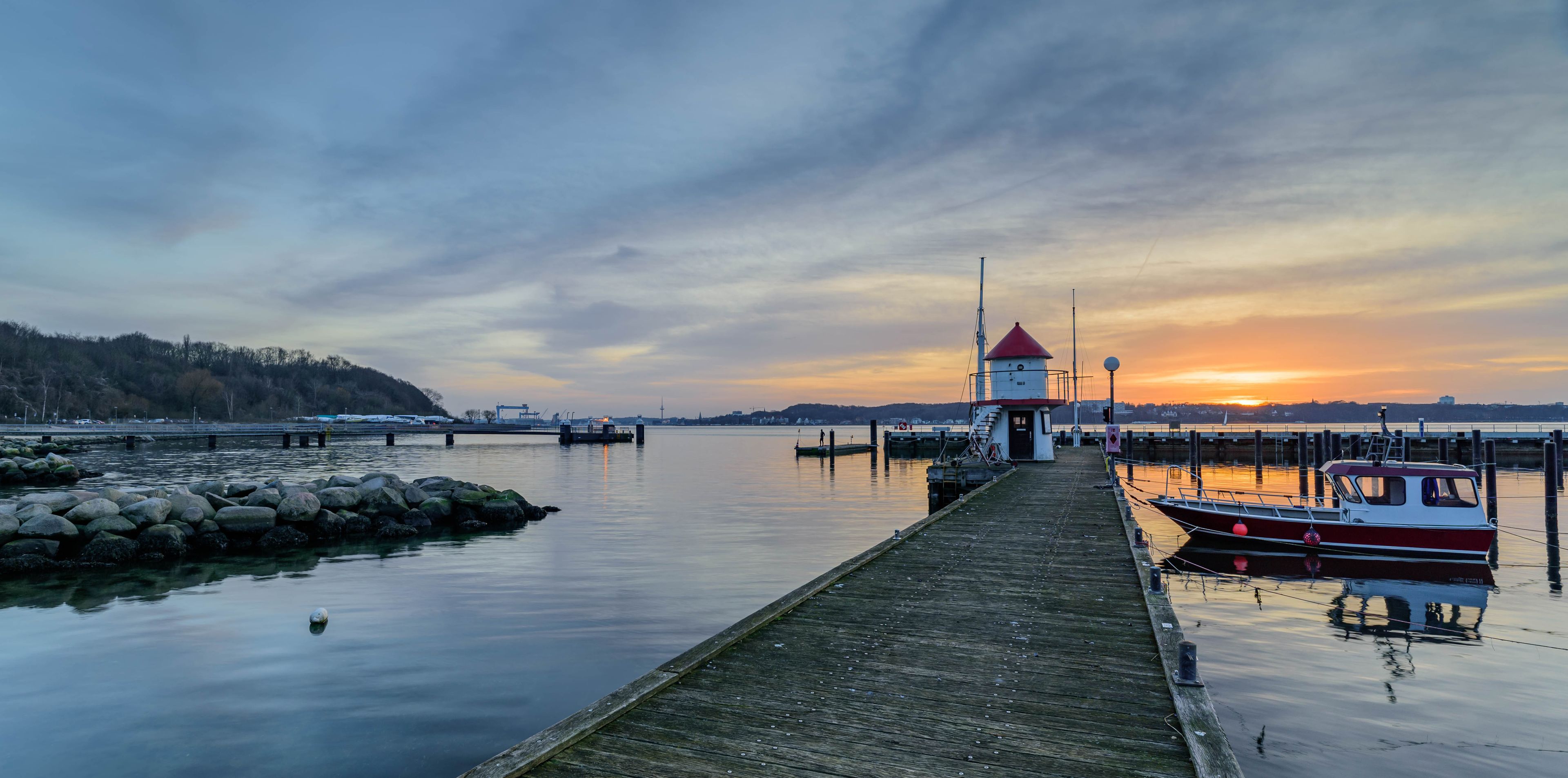 Panoramic view of the idyllic marina of Mönkeberg with the red and white tiny lighthouse, the "Juliusturm", the landmark of the Mönkeberg marina. View of Kiel Fjord and its lighthouse.