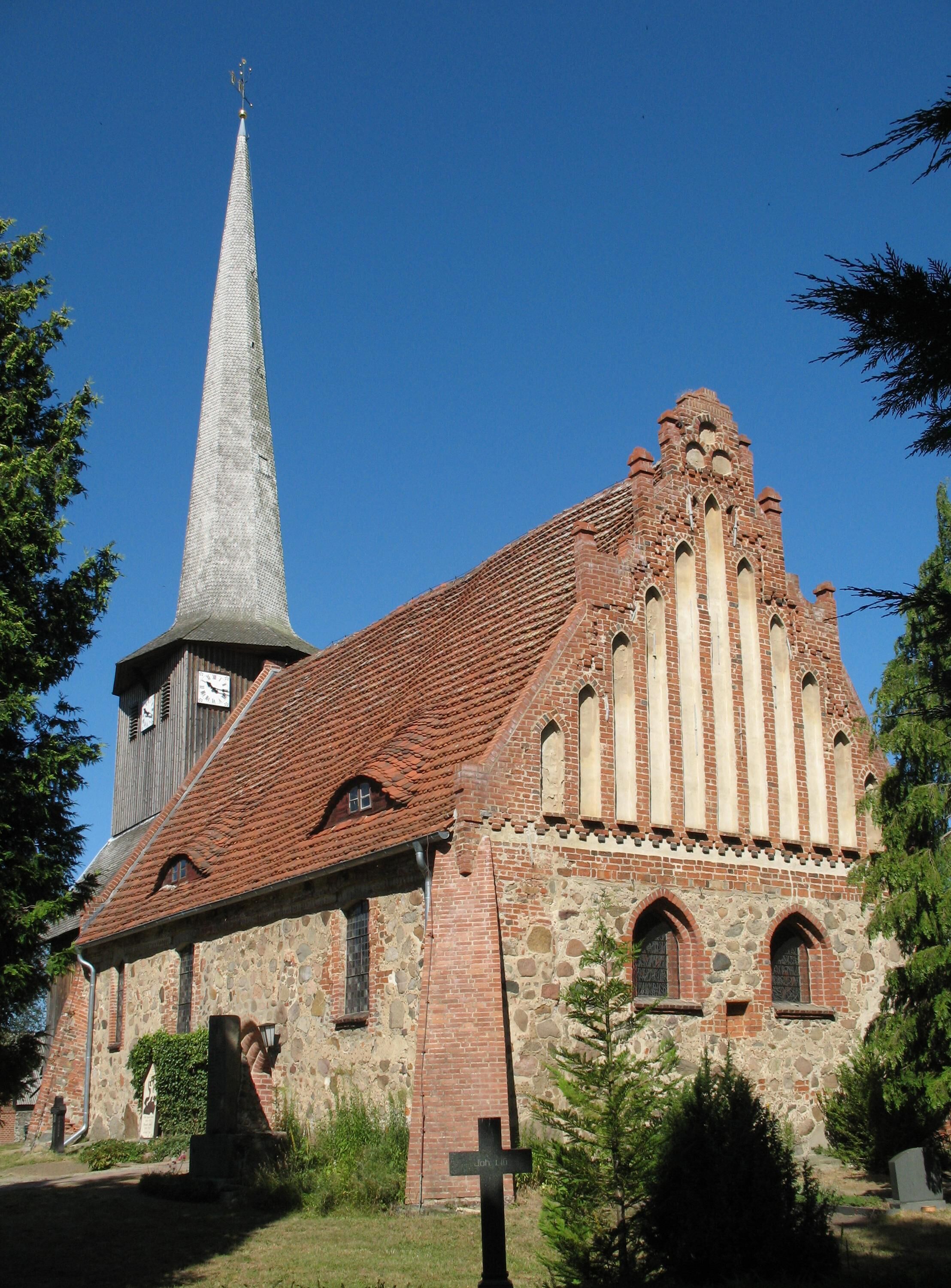 A church with a tall steeple and a brick facade.