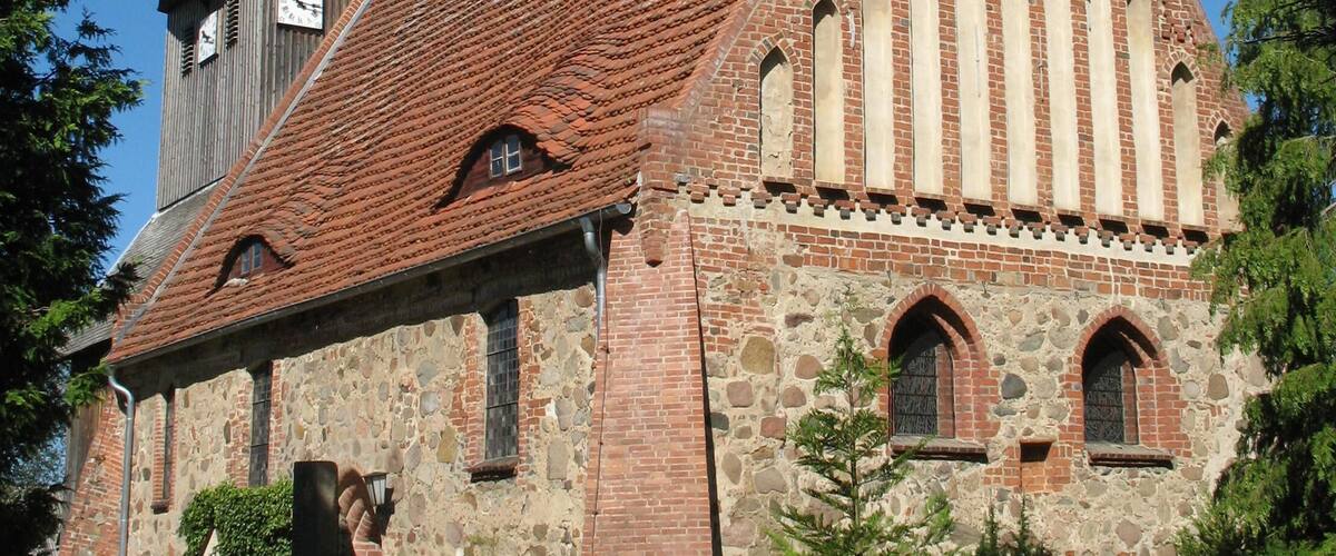 A church with a tall steeple and a brick facade.