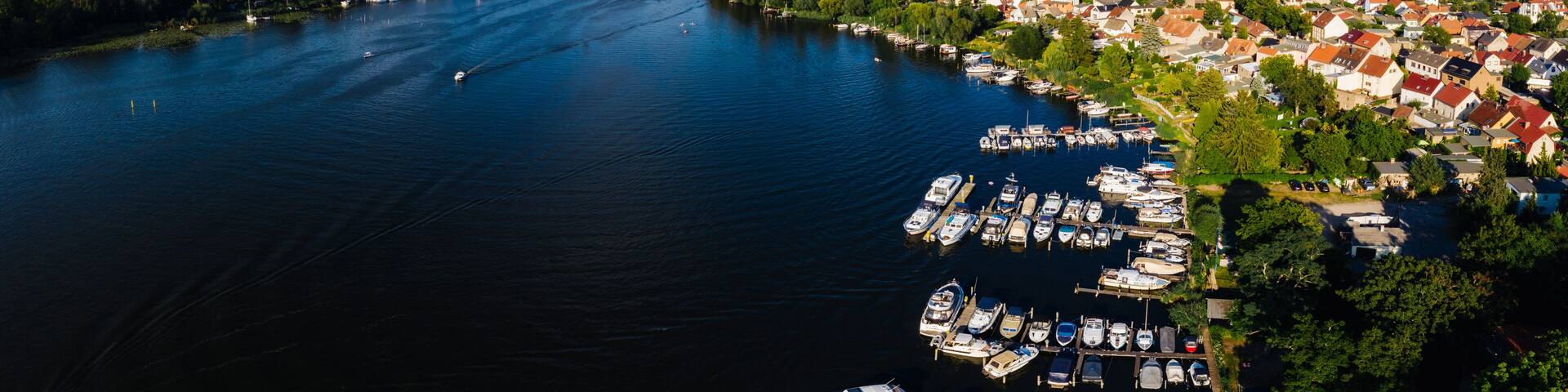 A lake surrounded by a town with boats docked along the shore.