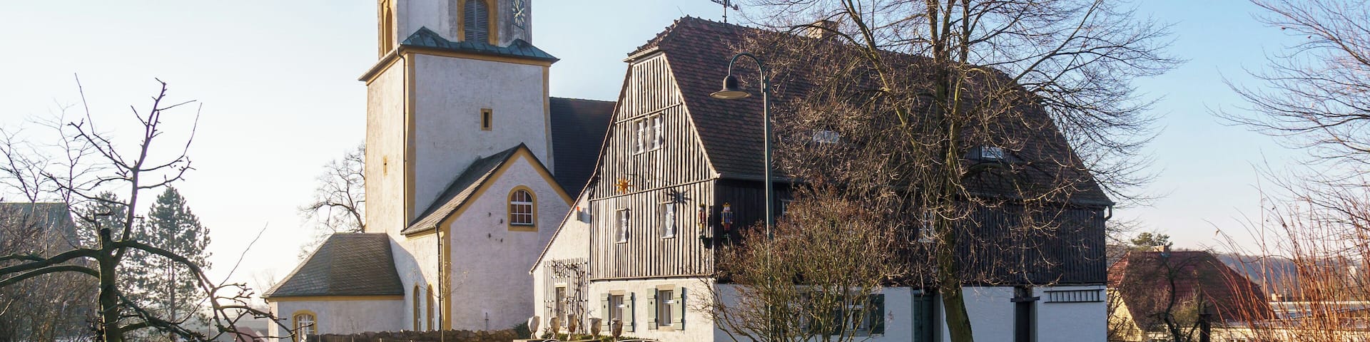 Una iglesia con un campanario alto y una torre del reloj.