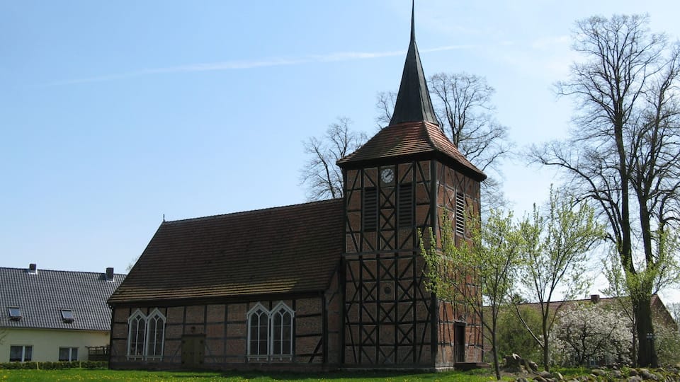 A church with a tall steeple and a clock tower.