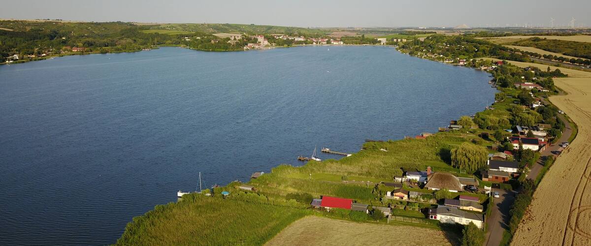 A large lake surrounded by green fields and houses.