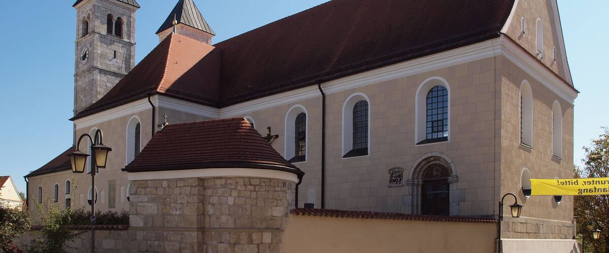 A church with a clock tower and a red roof.