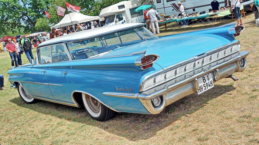 A classic blue 1954 Lincoln Continental convertible at a car show.