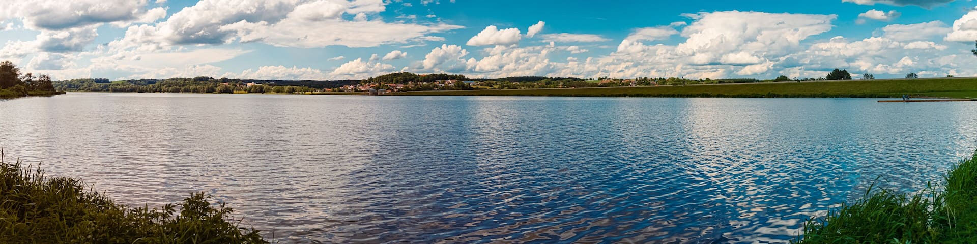 Summer view with reflections and a church at the famous Lake Vilstalsee, Reisbach, Marklkofen, Bavaria, Germany