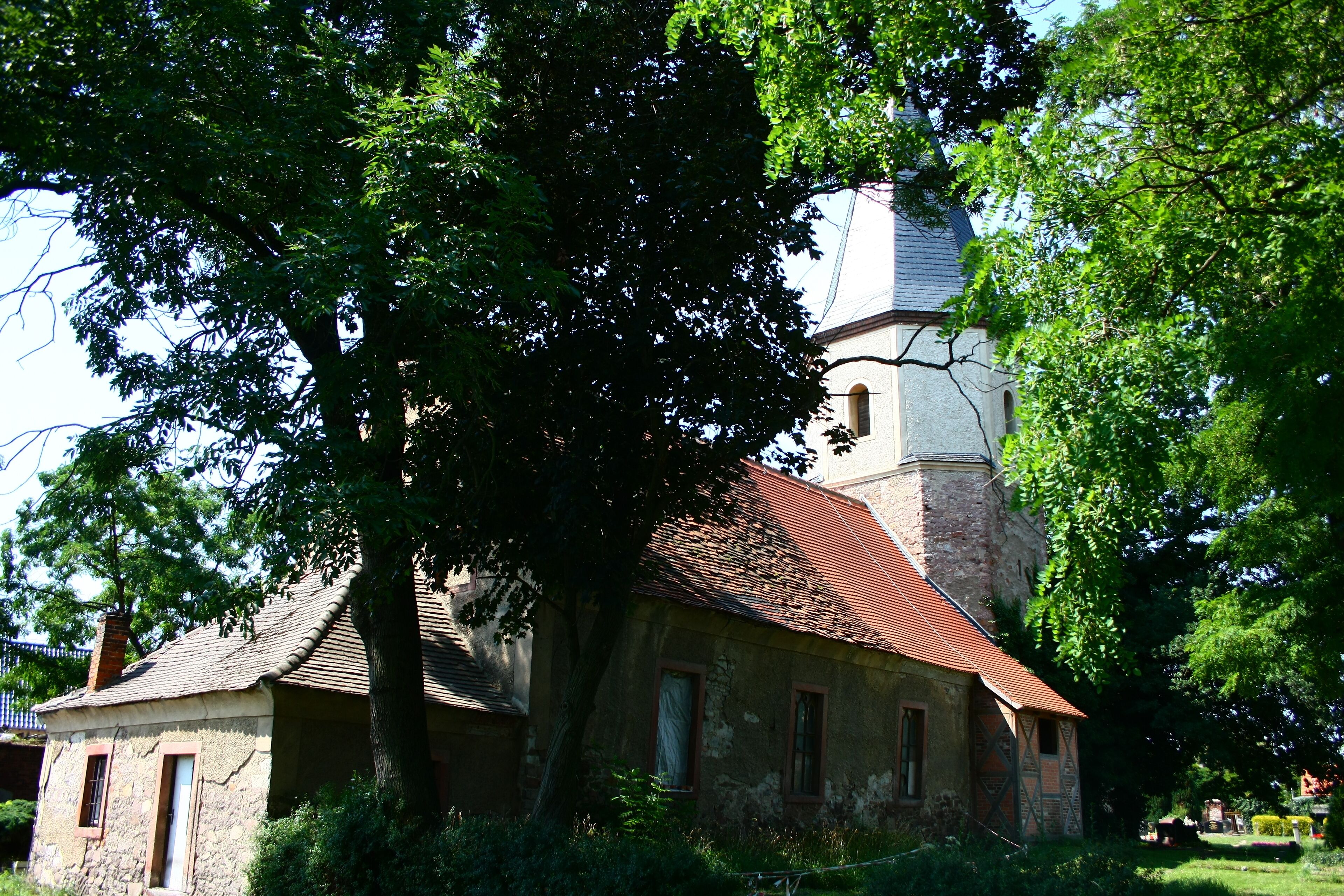 A church with a red roof and a stone tower.
