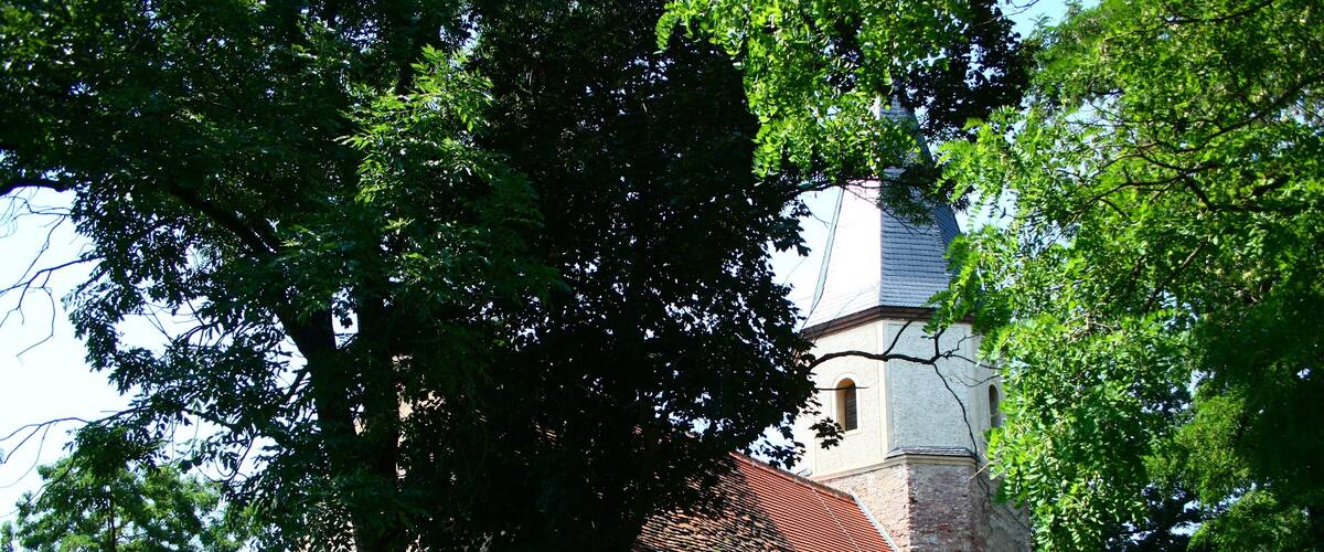 A church with a red roof and a stone tower.