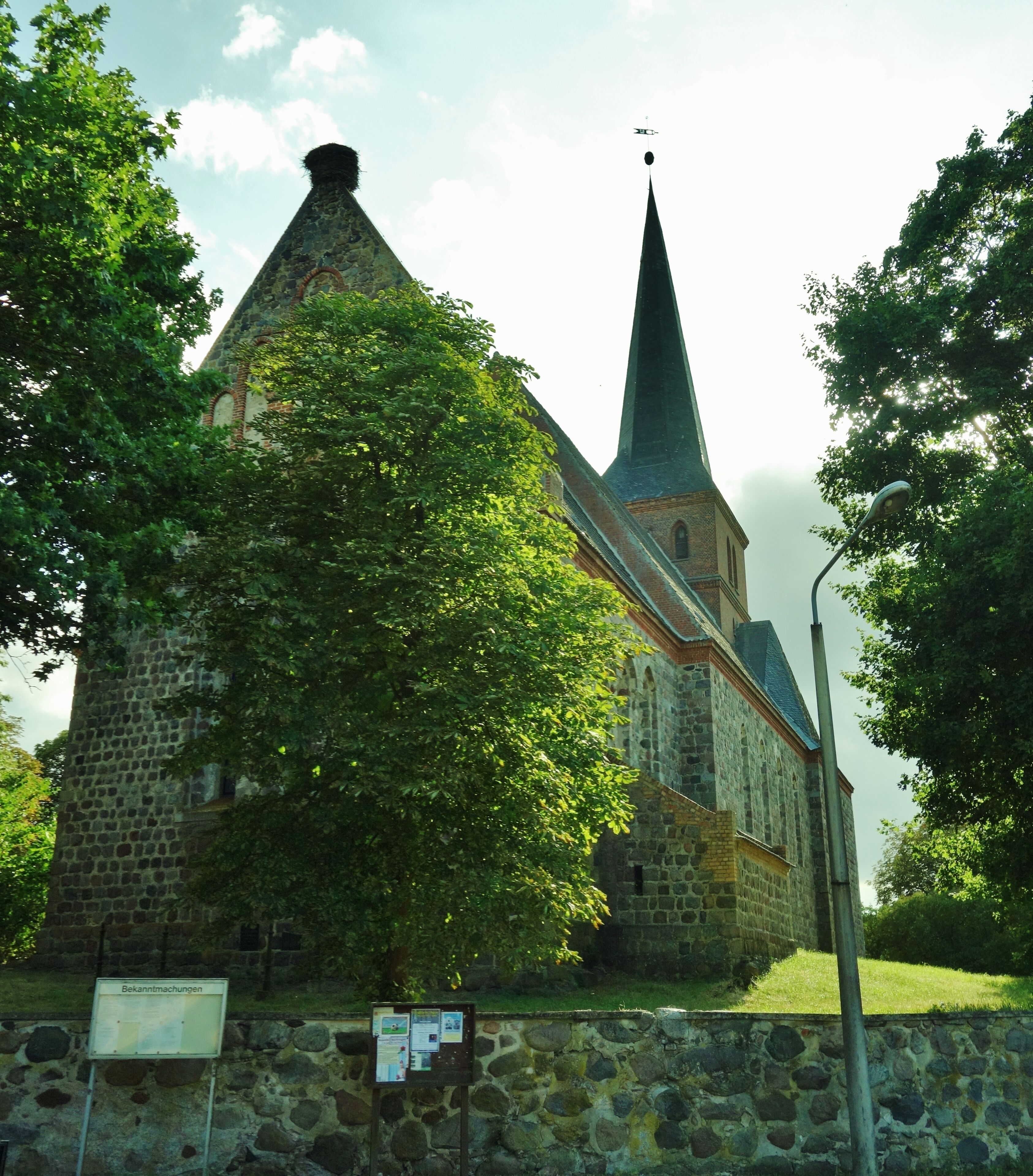 A church with a tall steeple and a stone tower.