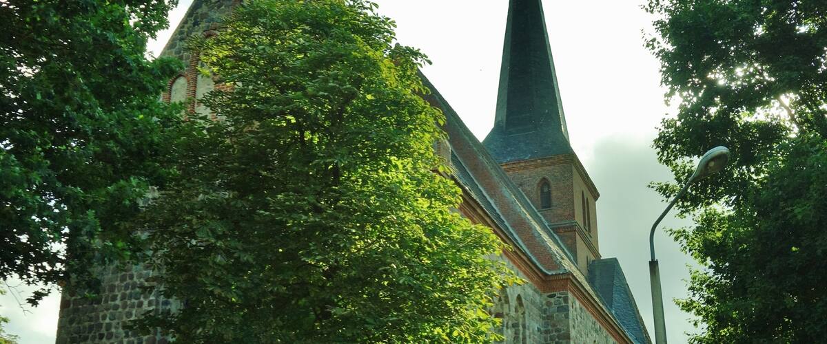 A church with a tall steeple and a stone tower.