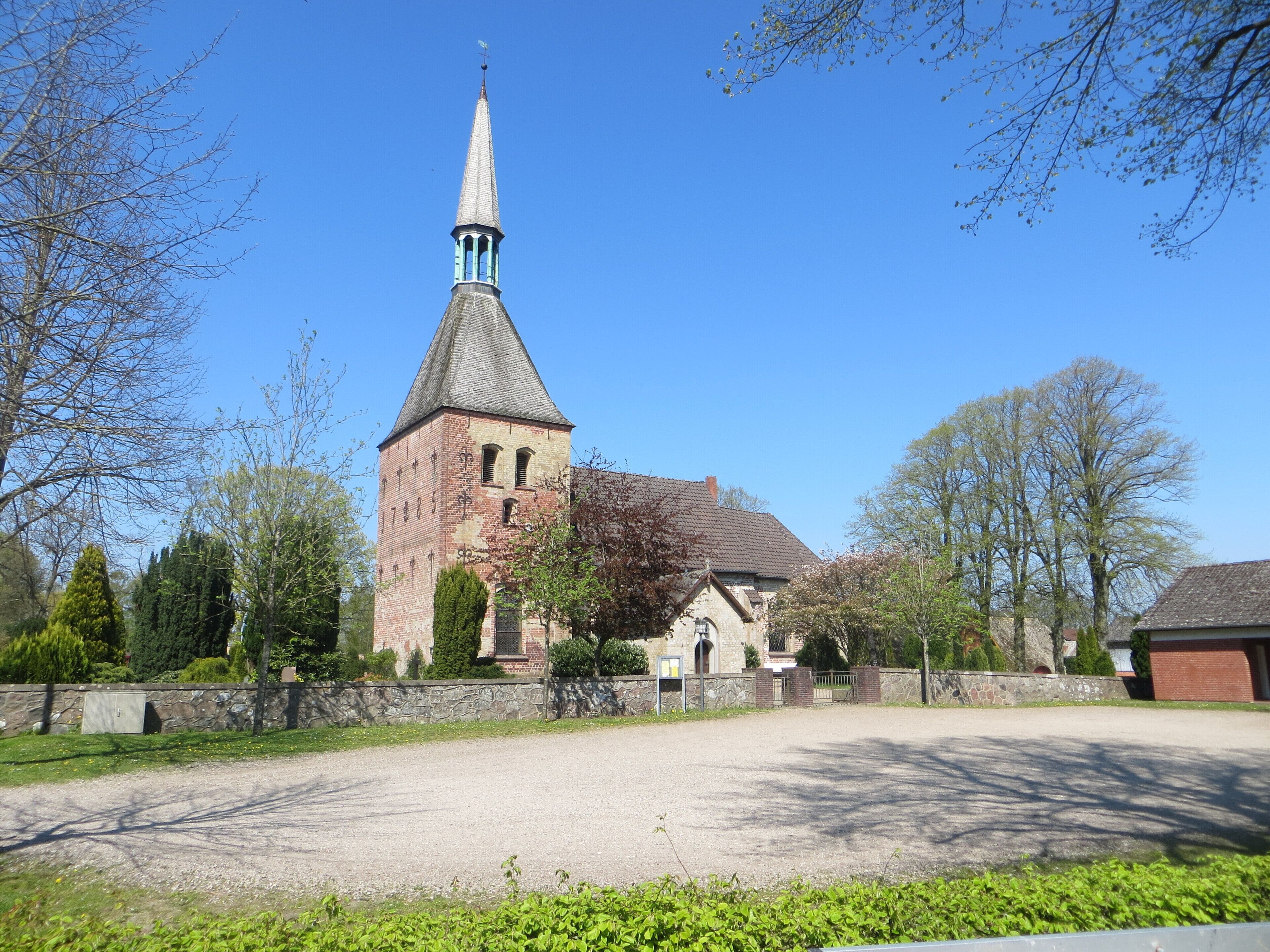 A church with a tall steeple and a brick tower.