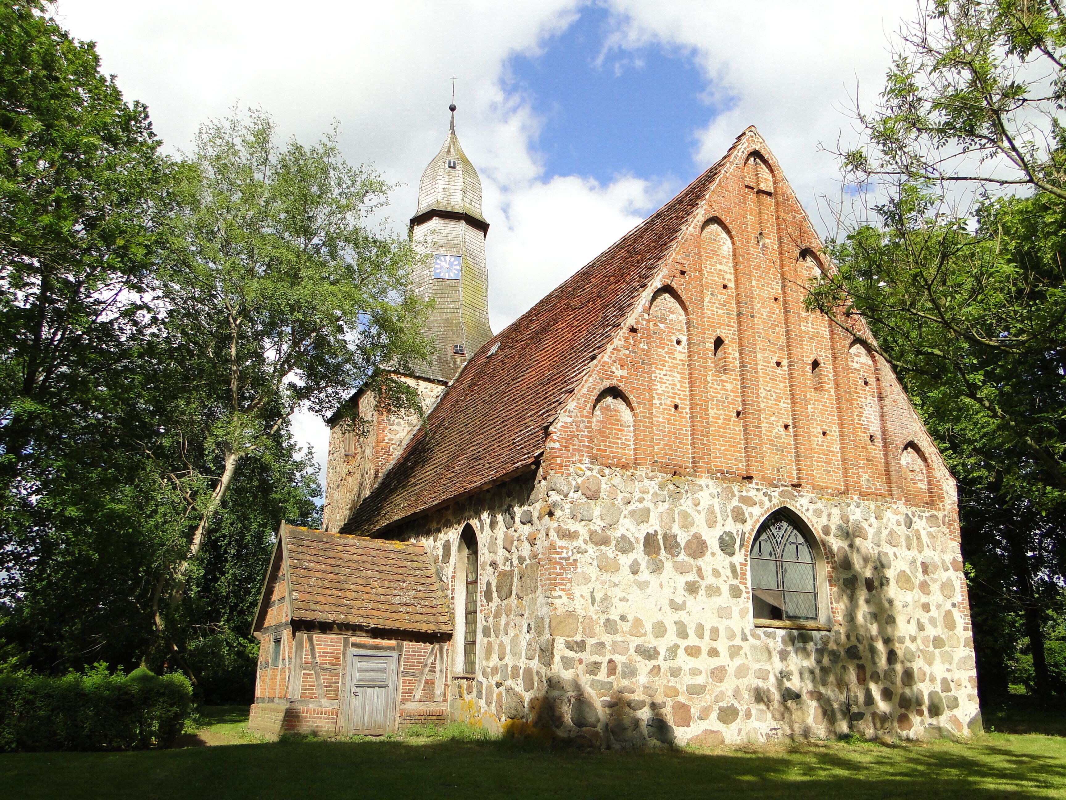 A historic church with a stone facade and a wooden bell tower.