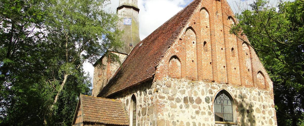 A historic church with a stone facade and a wooden bell tower.