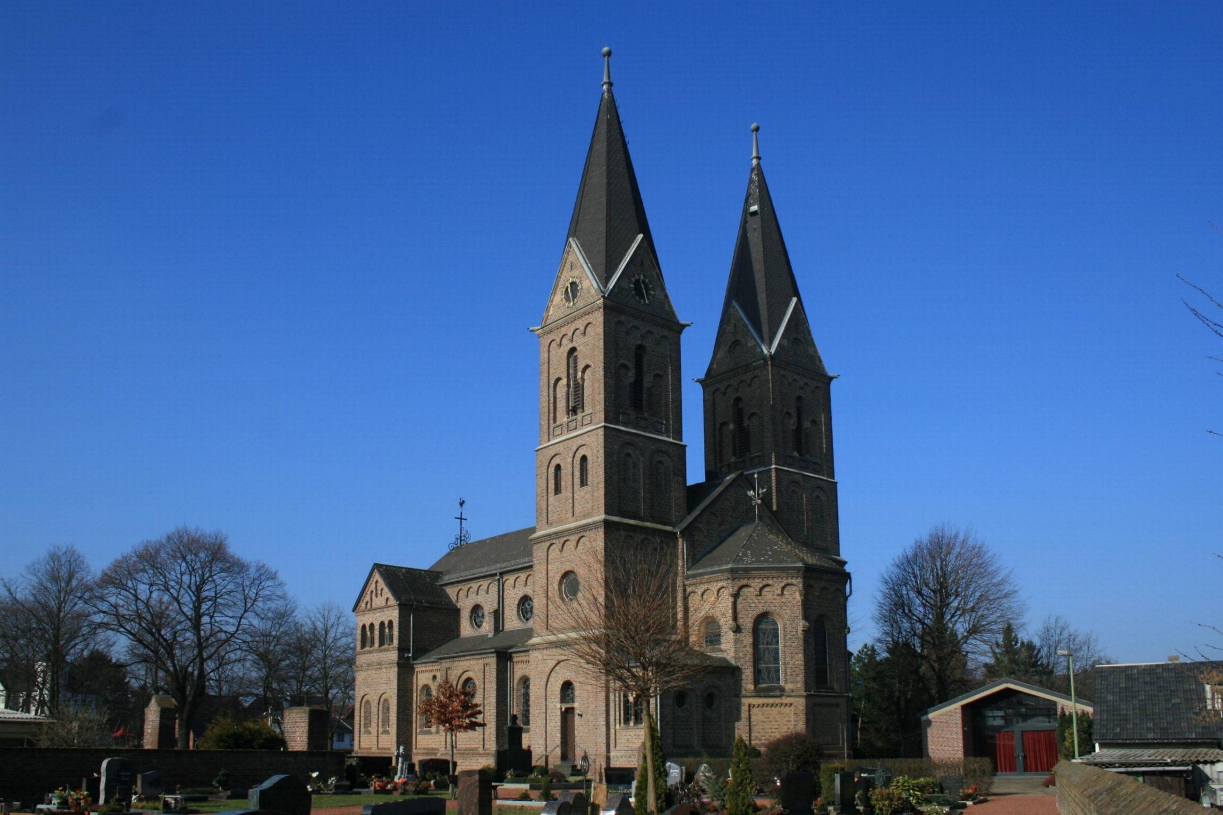 A church with two tall spires and a clock tower.