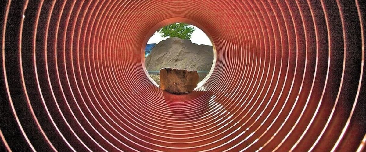 A circular tunnel with concentric red lines and a central rock formation.