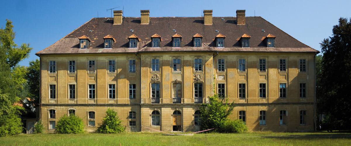 A large, historic building with a symmetrical facade, multiple windows, and a central entrance.