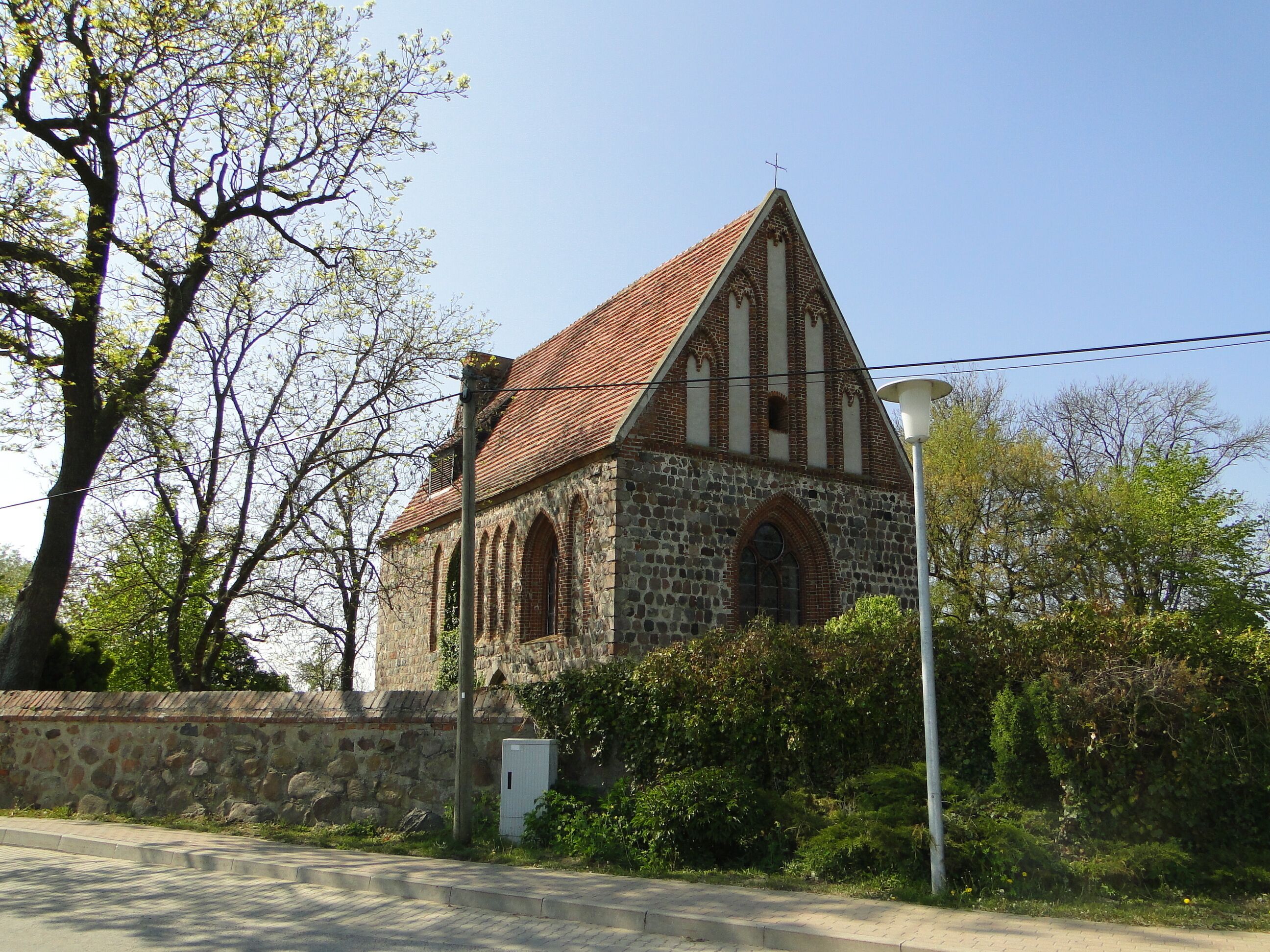 A stone church with a red-tiled roof and arched windows.