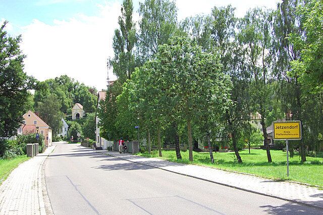 A tree-lined street with a sign reading "Jetzendorf."