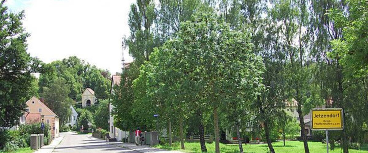A tree-lined street with a sign reading "Jetzendorf."